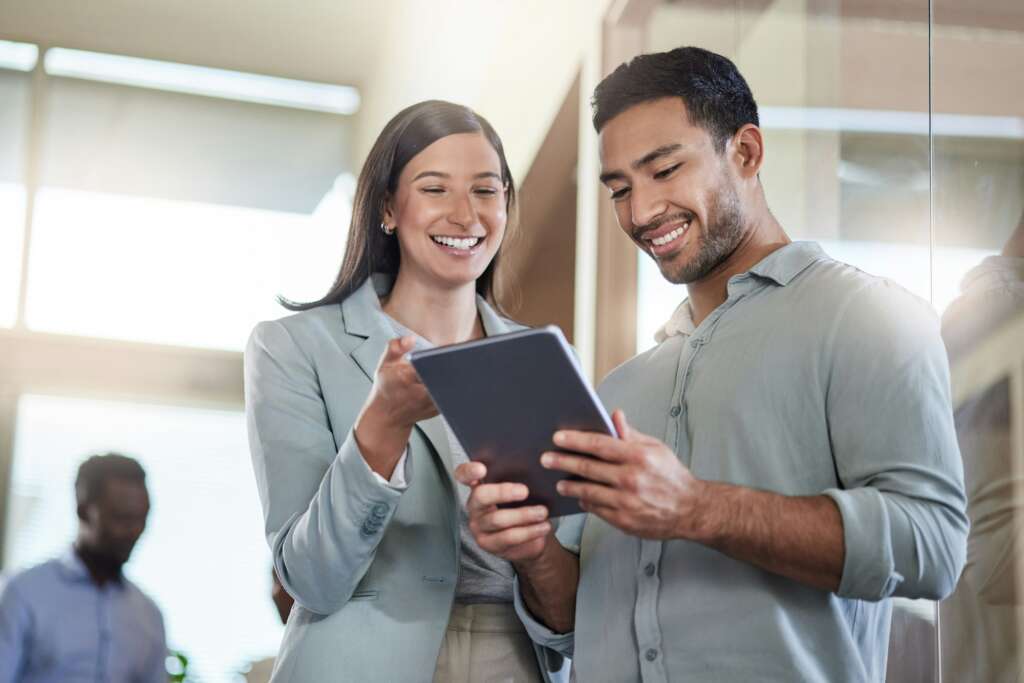 2 people look at an iPad