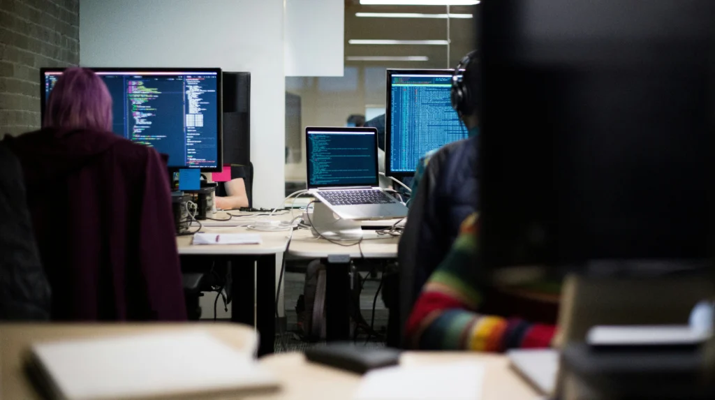 People in an office working coding on computers