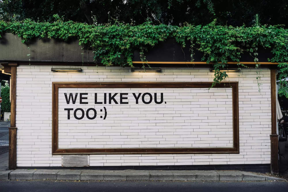a sign on a wall reads "we like you"